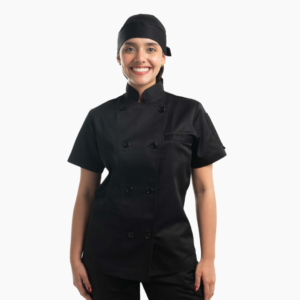 Chef sonriente luciendo uniforme negro completo con filipina de manga corta y gorro.