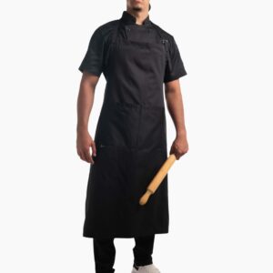 Hombre posando con un delantal de cocina negro de pechera ajustable y bolsillo frontal amplio.