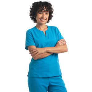 Mujer sonriente con cabello rizado posando con los brazos cruzados y vistiendo el uniforme médico Esmeralda en color azul celeste, compuesto por una filipina de manga corta con cuello estilizado y pantalón a juego sobre un fondo negro.